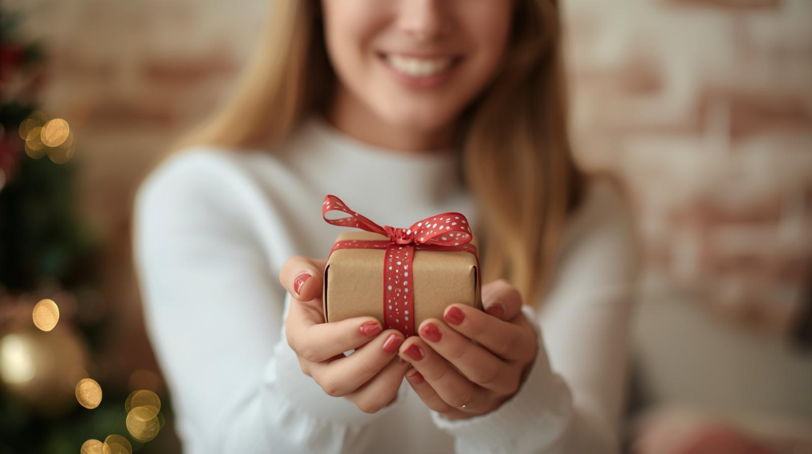 Une femme offre un cadeau pour Noël