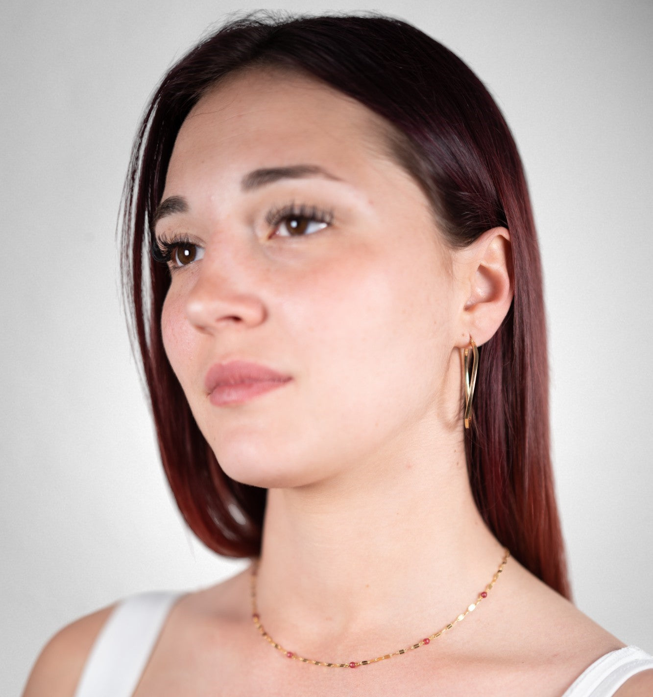 Large oval hoop earrings and red quartz necklace