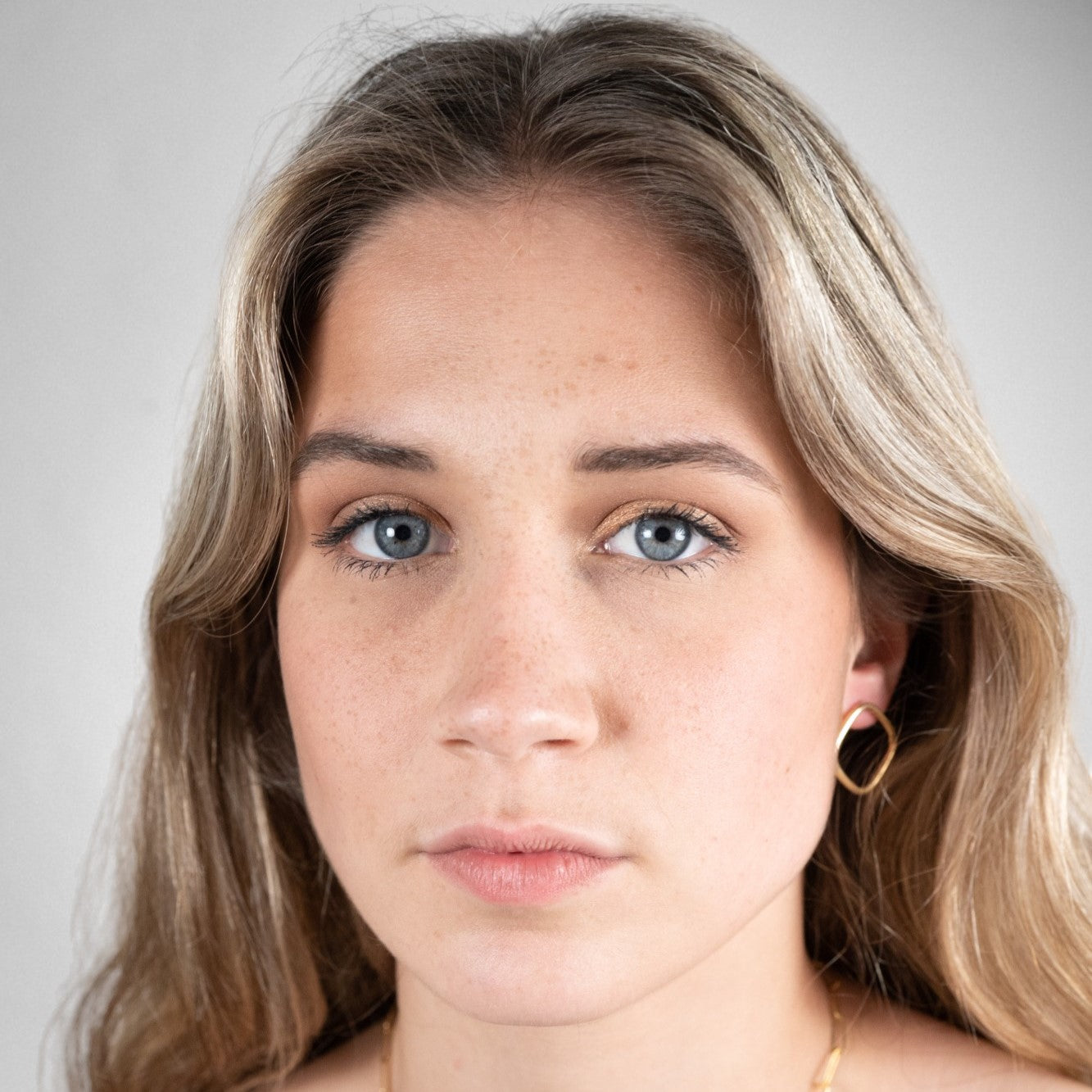Yellow gold-plated 925 sterling silver diamond earrings worn on a model