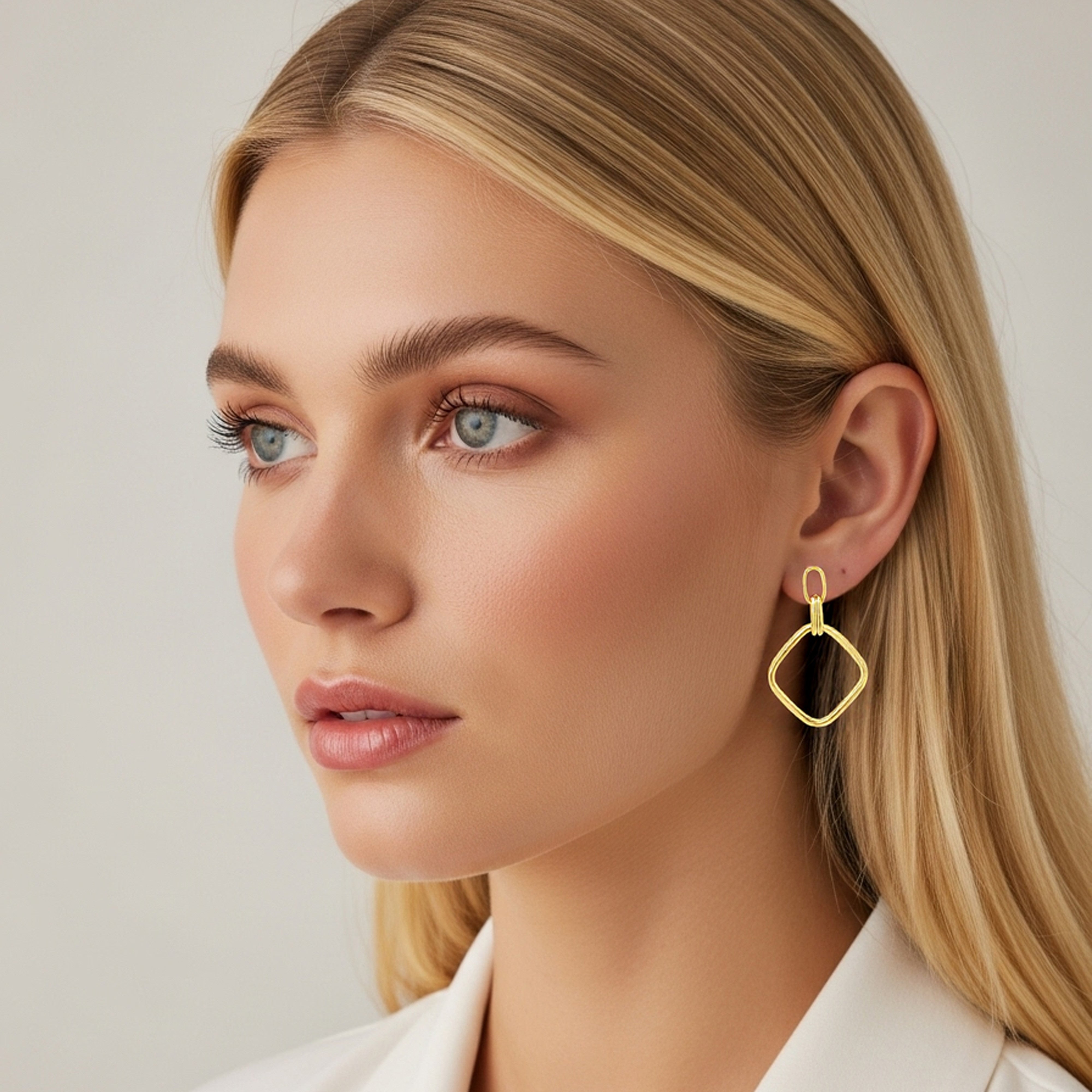 Femme portant une boucle d'oreille carrée pendante de couleur or jaune