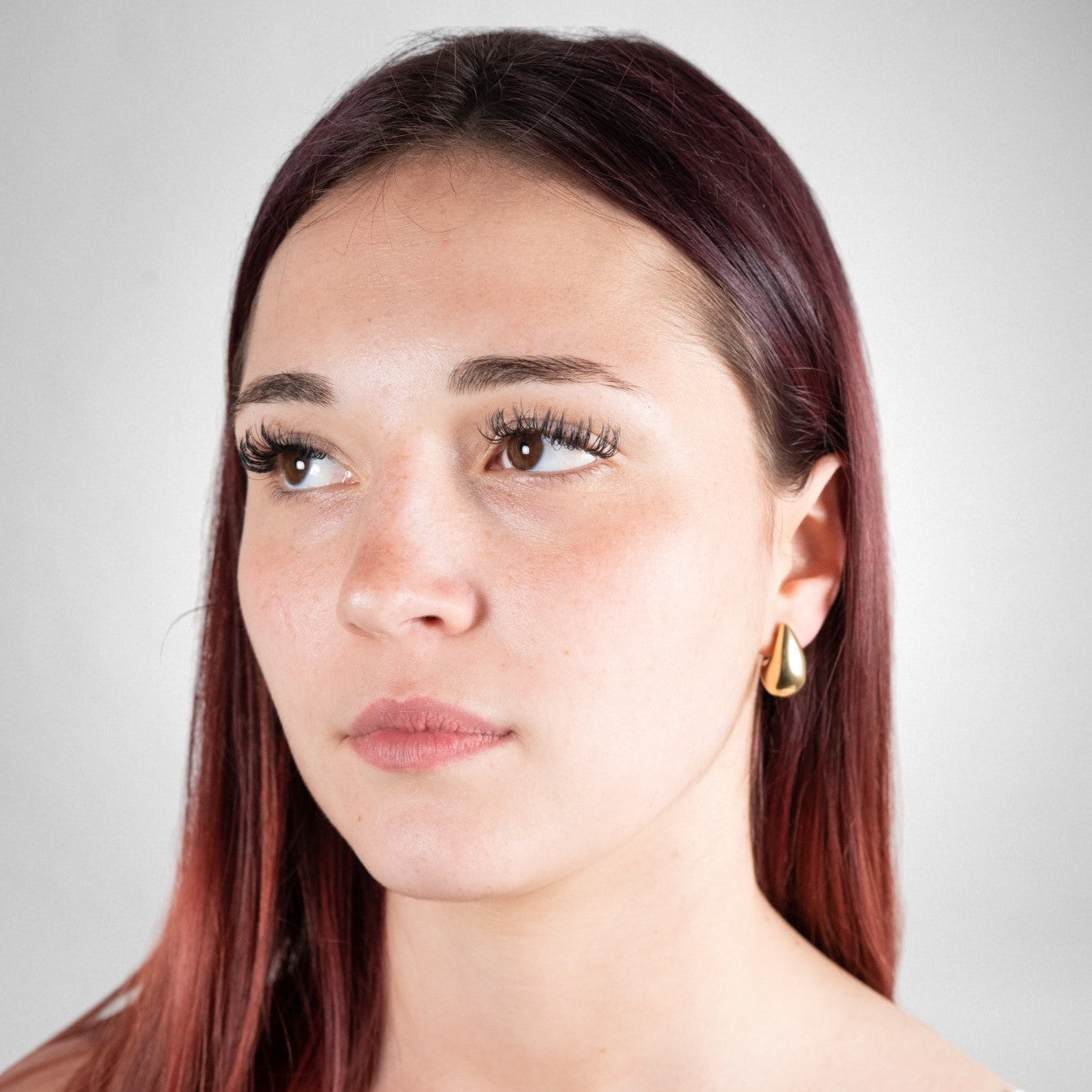 Boucles d'oreilles goutte d'eau en argent 925 plaqué or jaune portées sur un modèle