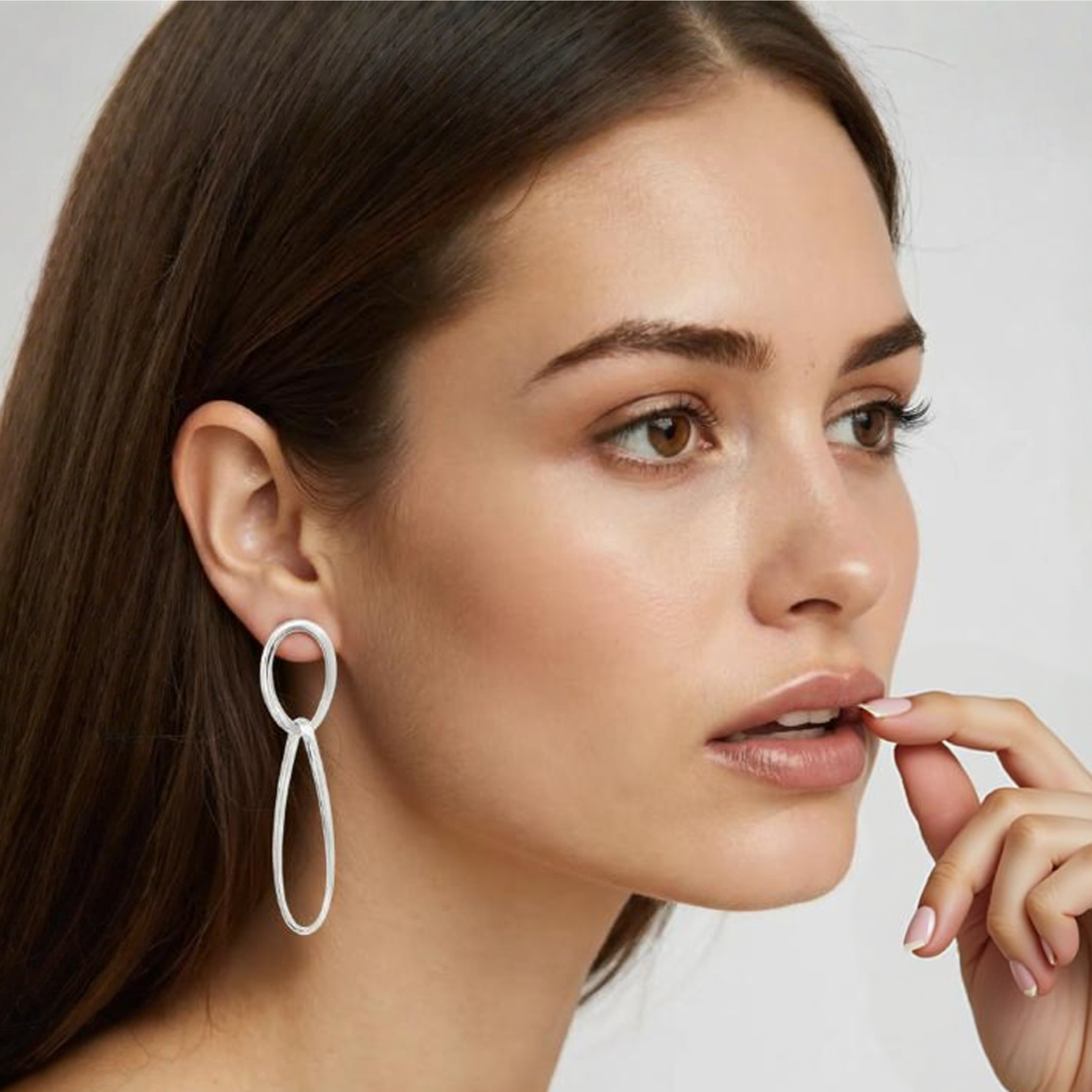 Femme porte des boucles d'oreilles pendantes ovales en argent massif