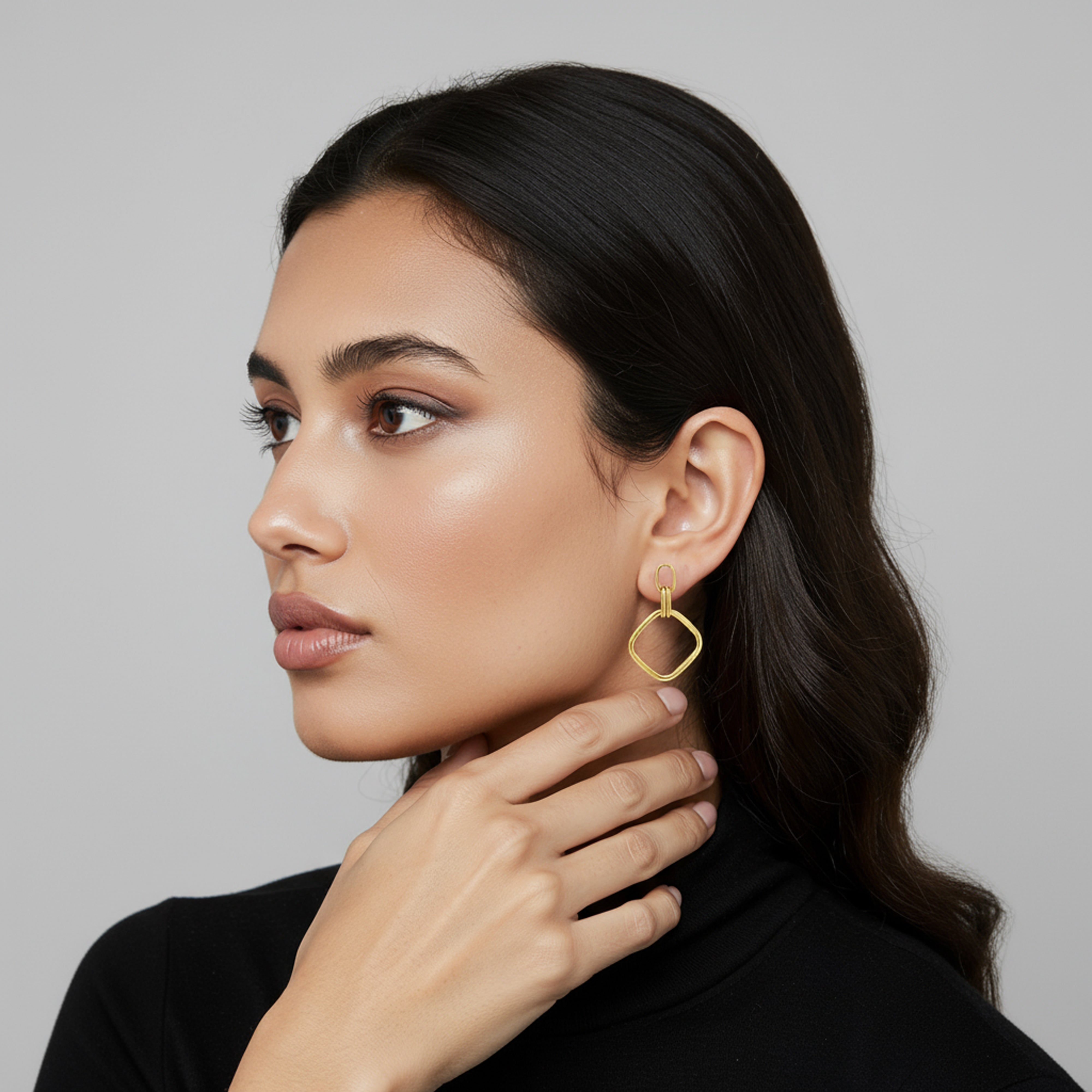 Boucle d'oreille carrée pendante portée par une femme aux cheveux noirs