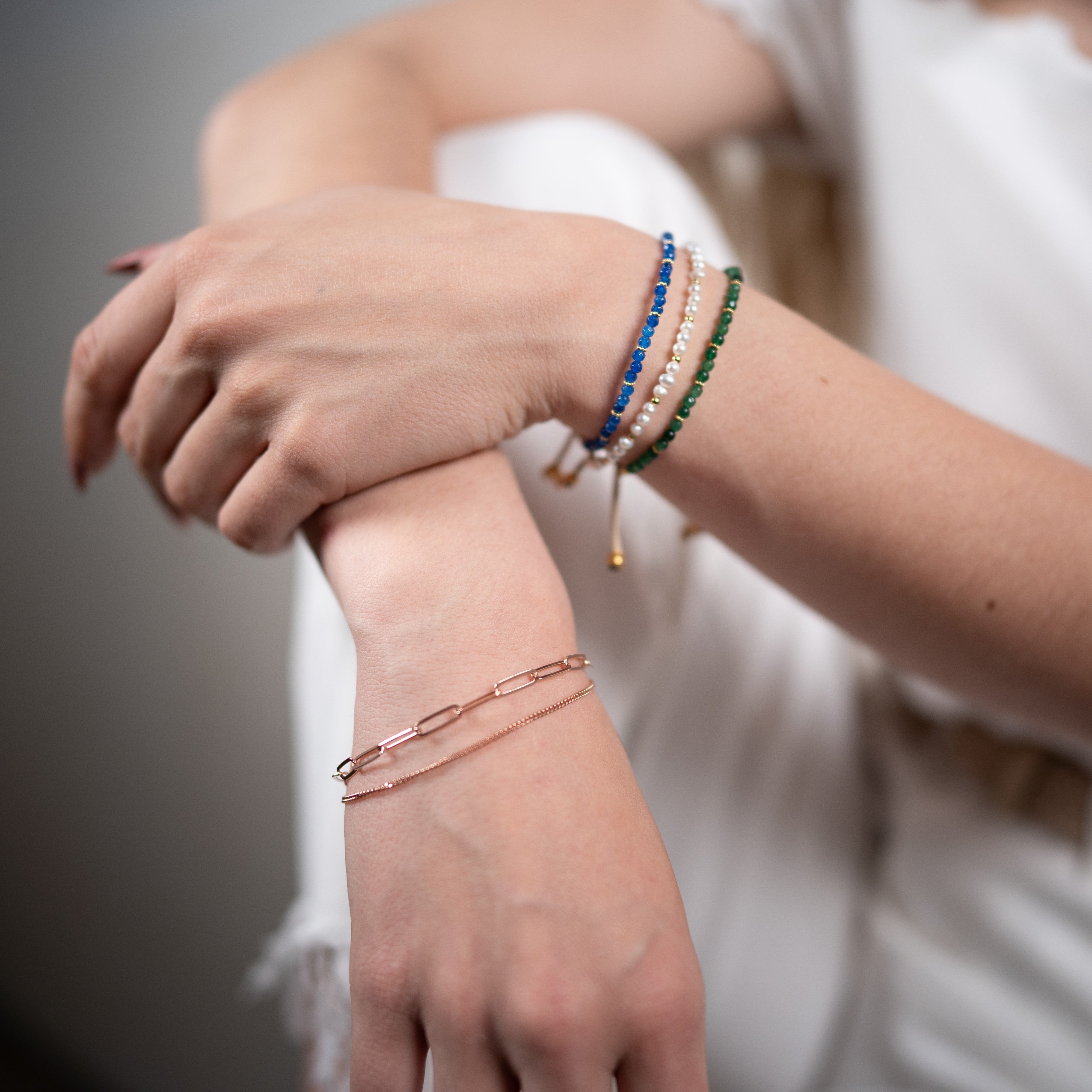 Diversi bracciali di quarzo e un bracciale a due file di catene in oro rosa