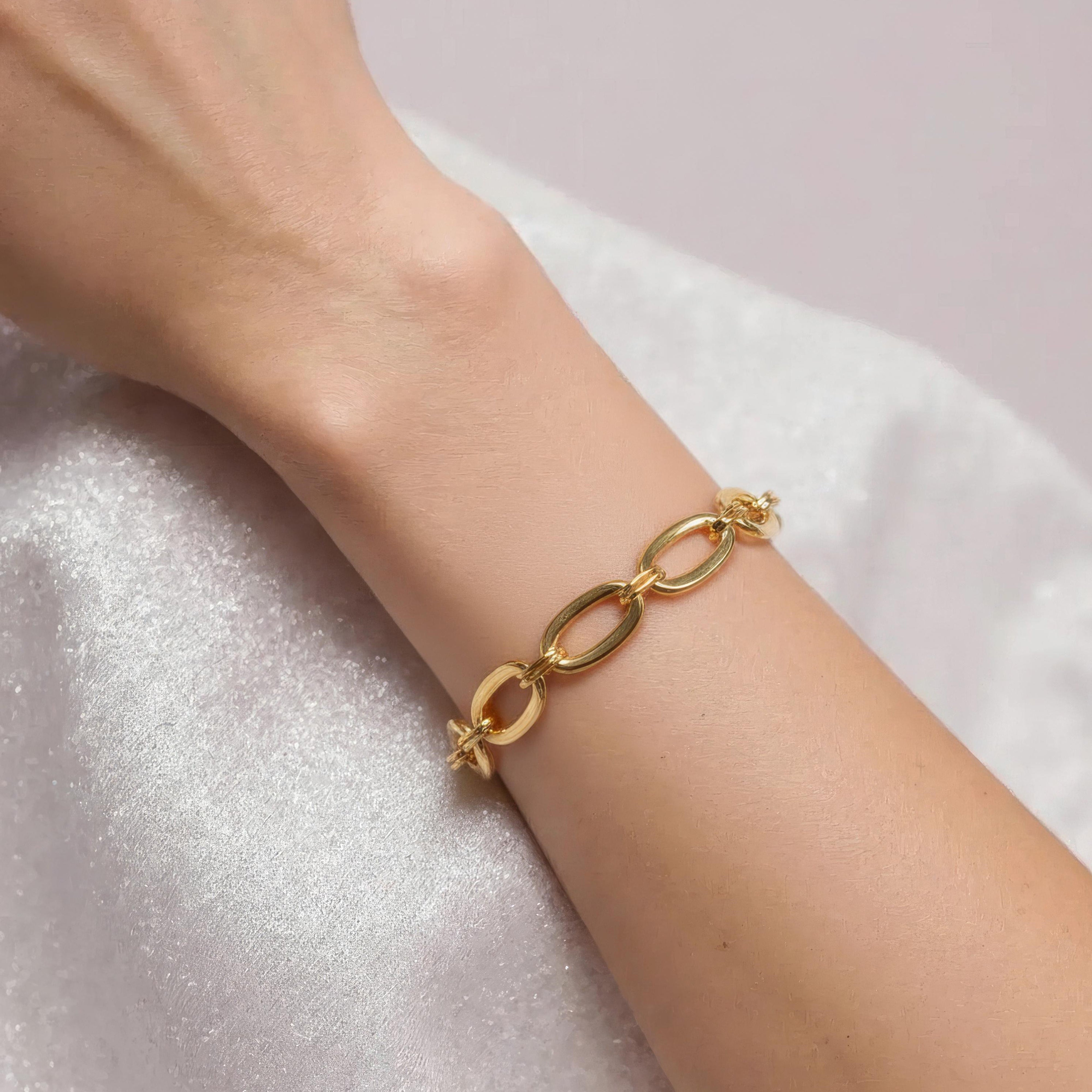 Bracelet gros maillon or porté au poignet d'une femme