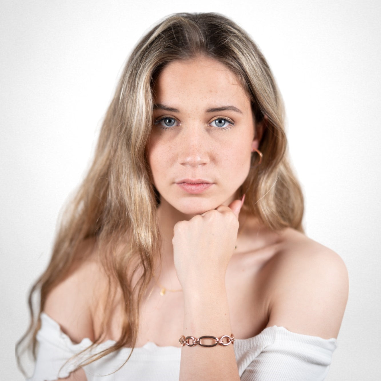 Bracciale a maglie grandi in argento placcato oro rosa indossato da una donna con orecchini a cerchio