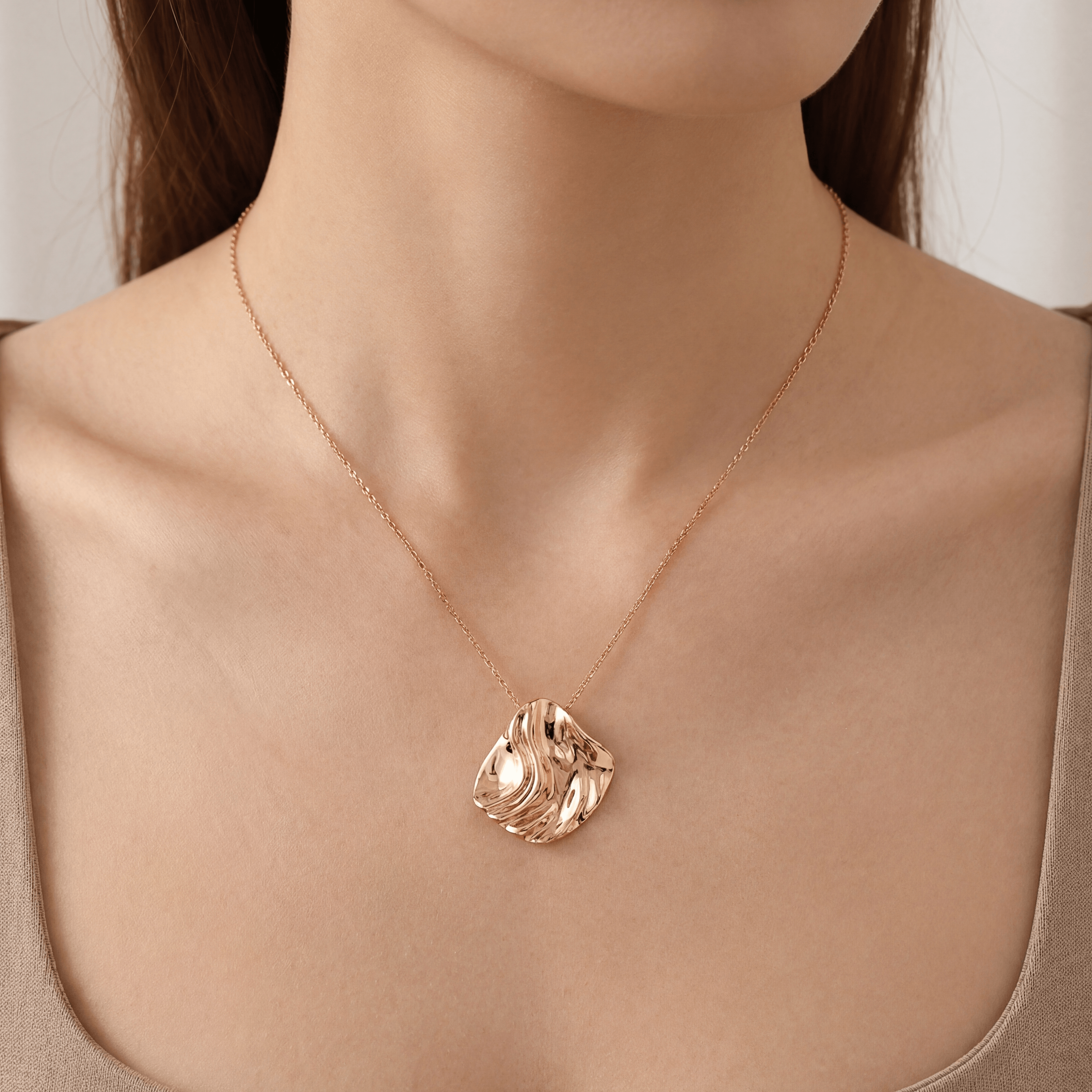 Un modèle porte le pendentif carré organique