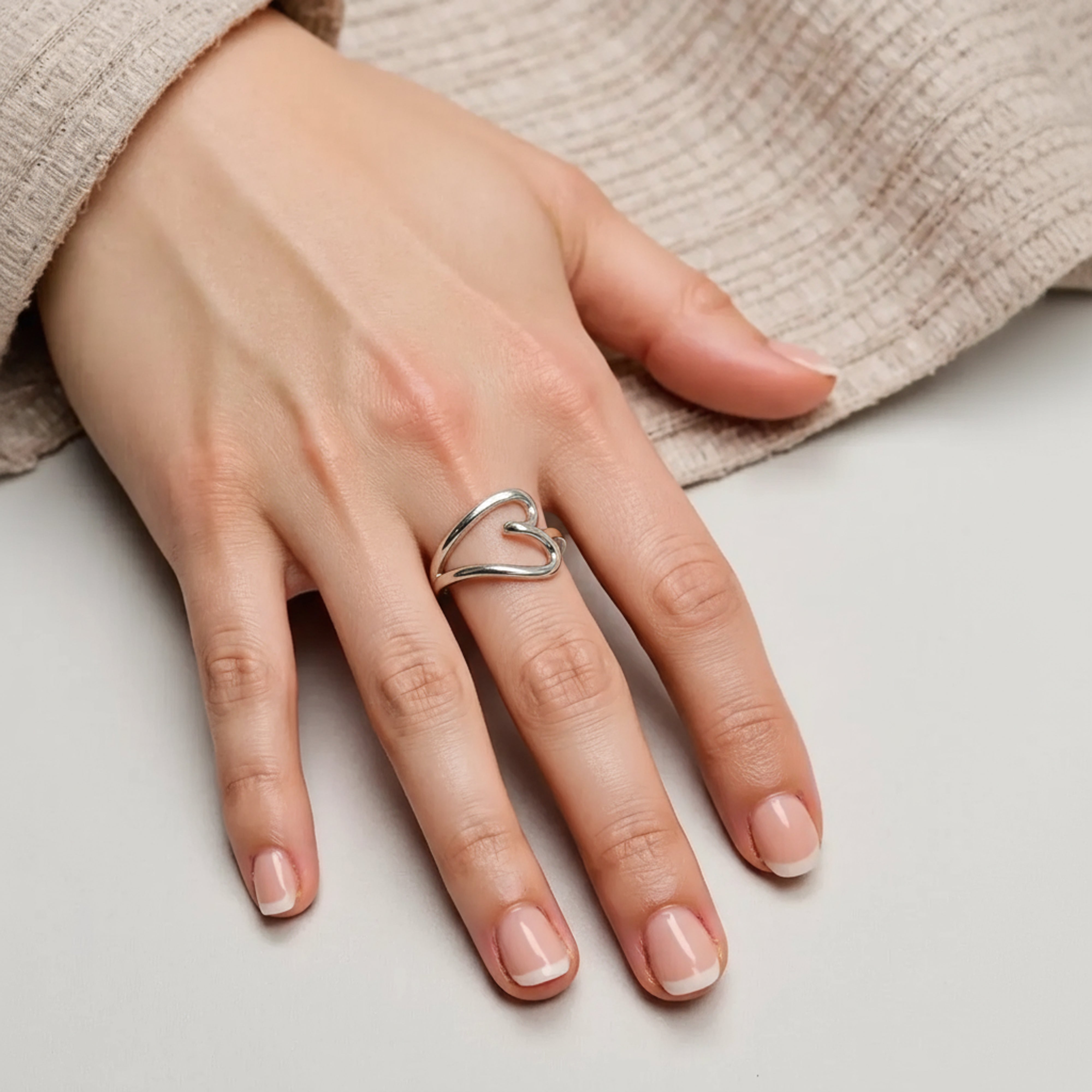 Bague coeur en argent massif portée au doigt
