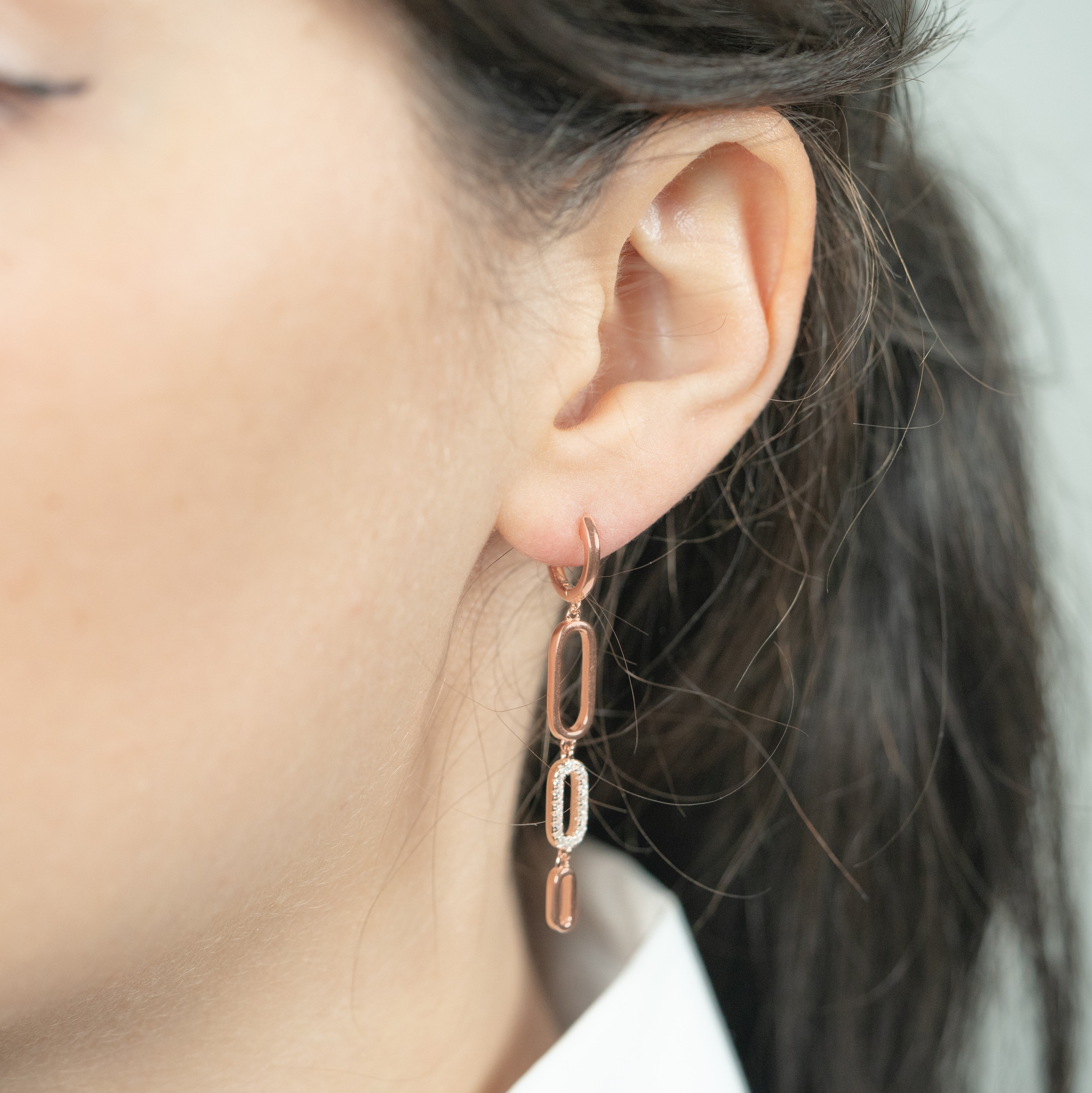 Long zirconium earrings in rose gold worn on a model