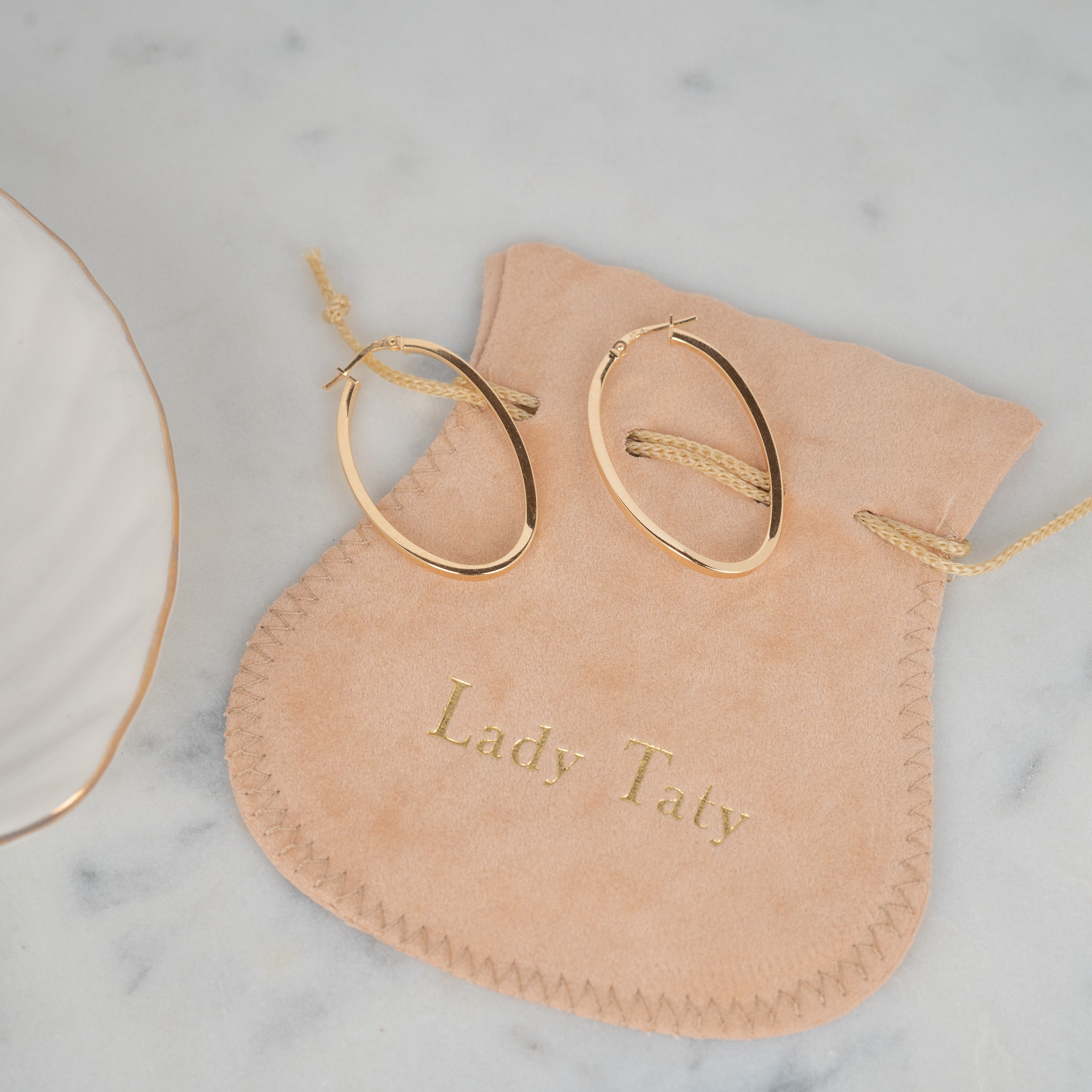 Boucles d'oreilles en argent 925 ovales posées sur une pochette chamois