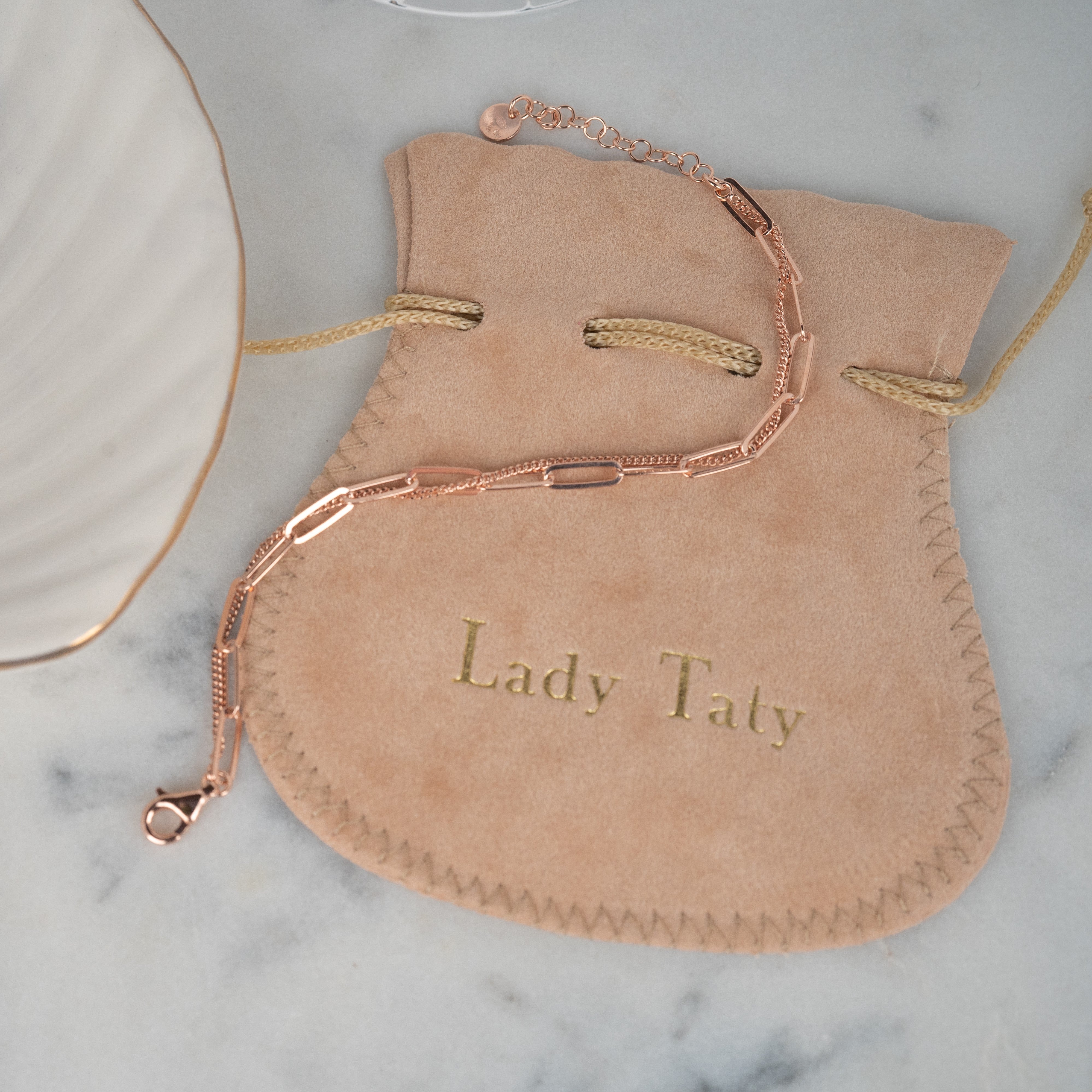 Bracelet chaîne deux rangs en argent couleur or rose posé sur une pochette chamois