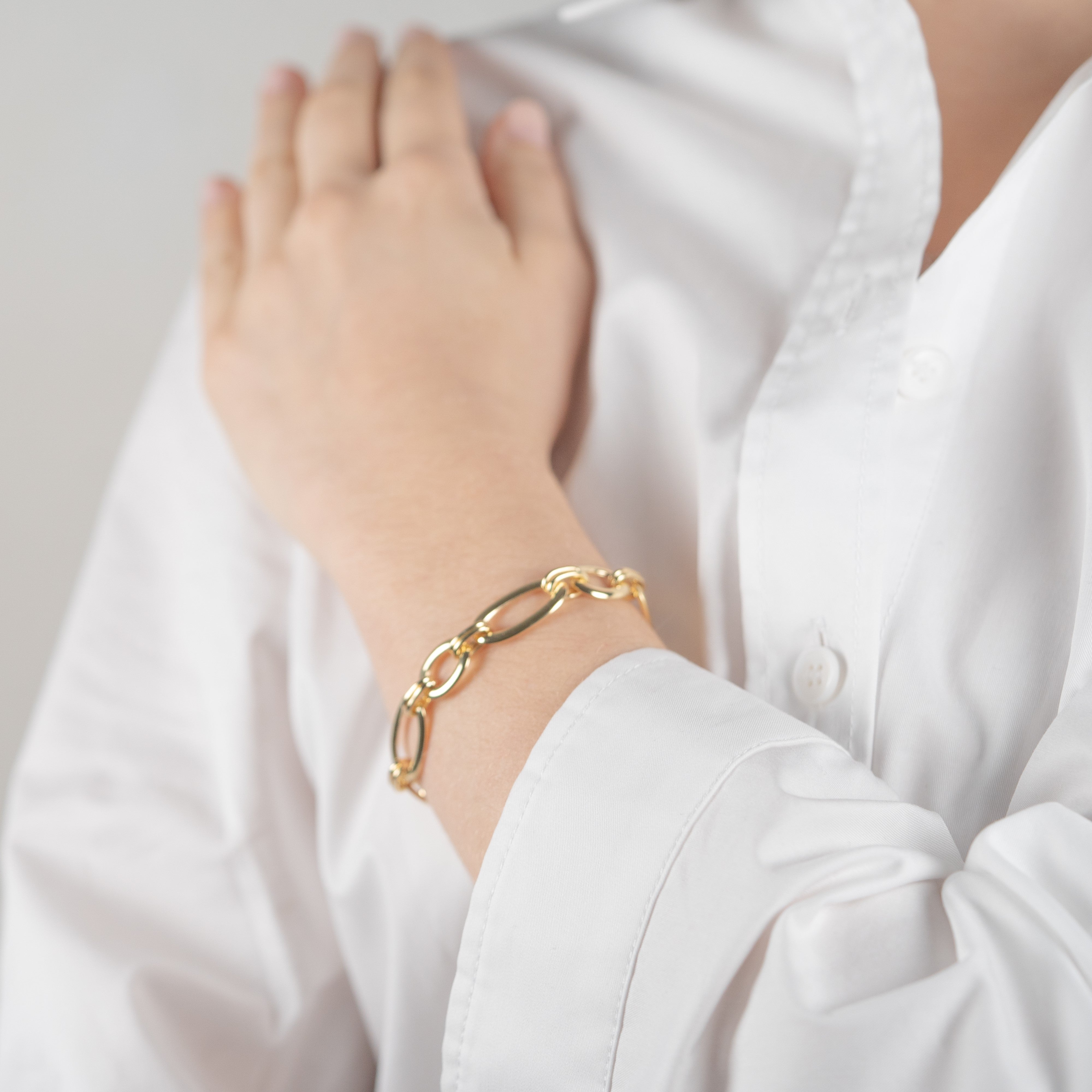 Bracelet gros maillon en argent plaqué or jaune porté par une femme