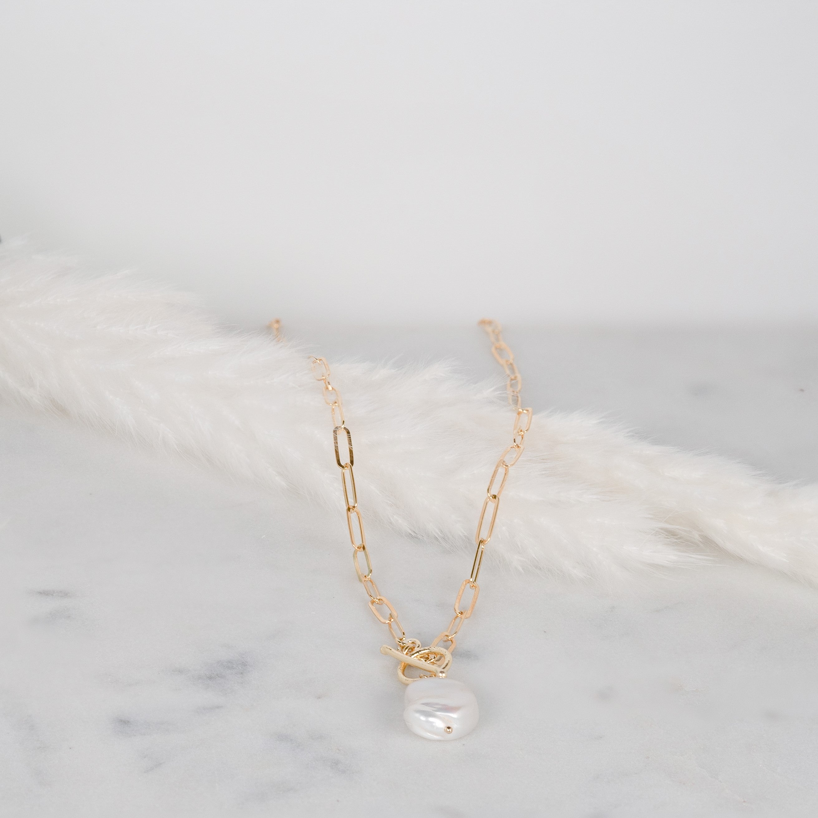 Collana in argento 925 con perla coltivata incastonata su una piuma bianca