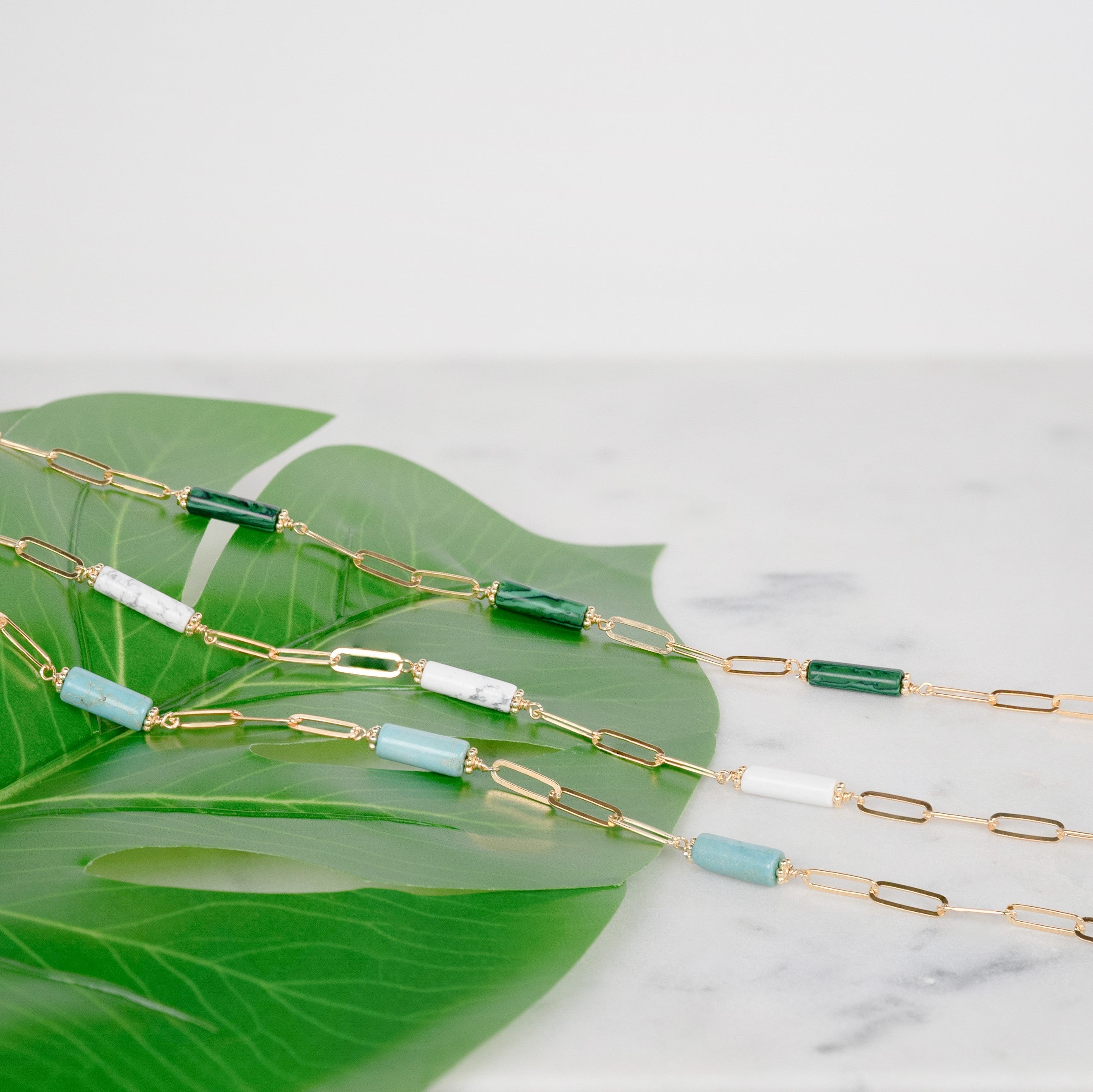 Tre collane di pietre, tra cui una collana di malachite, una collana di turchese e una collana di howlite