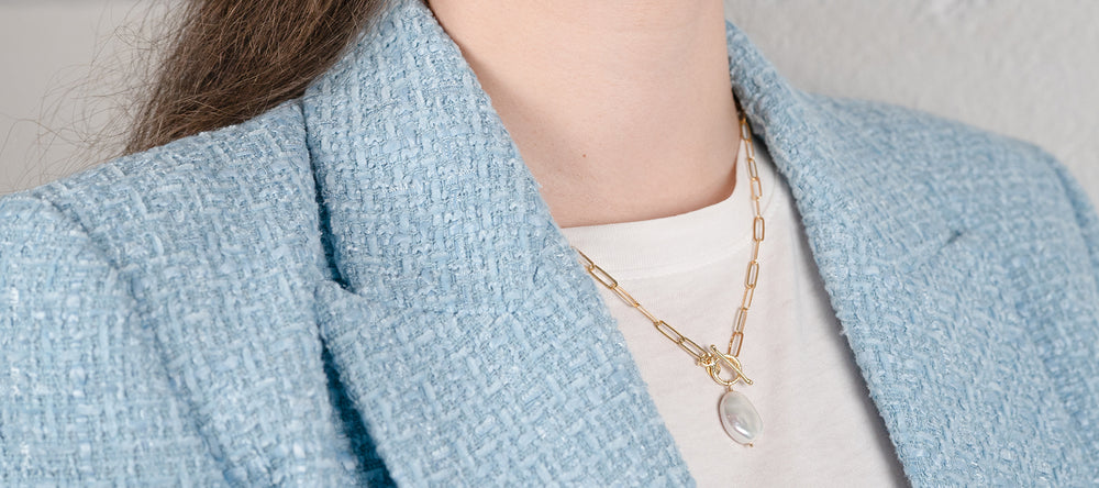 Magnifique collier avec une perle portée sur une veste bleue