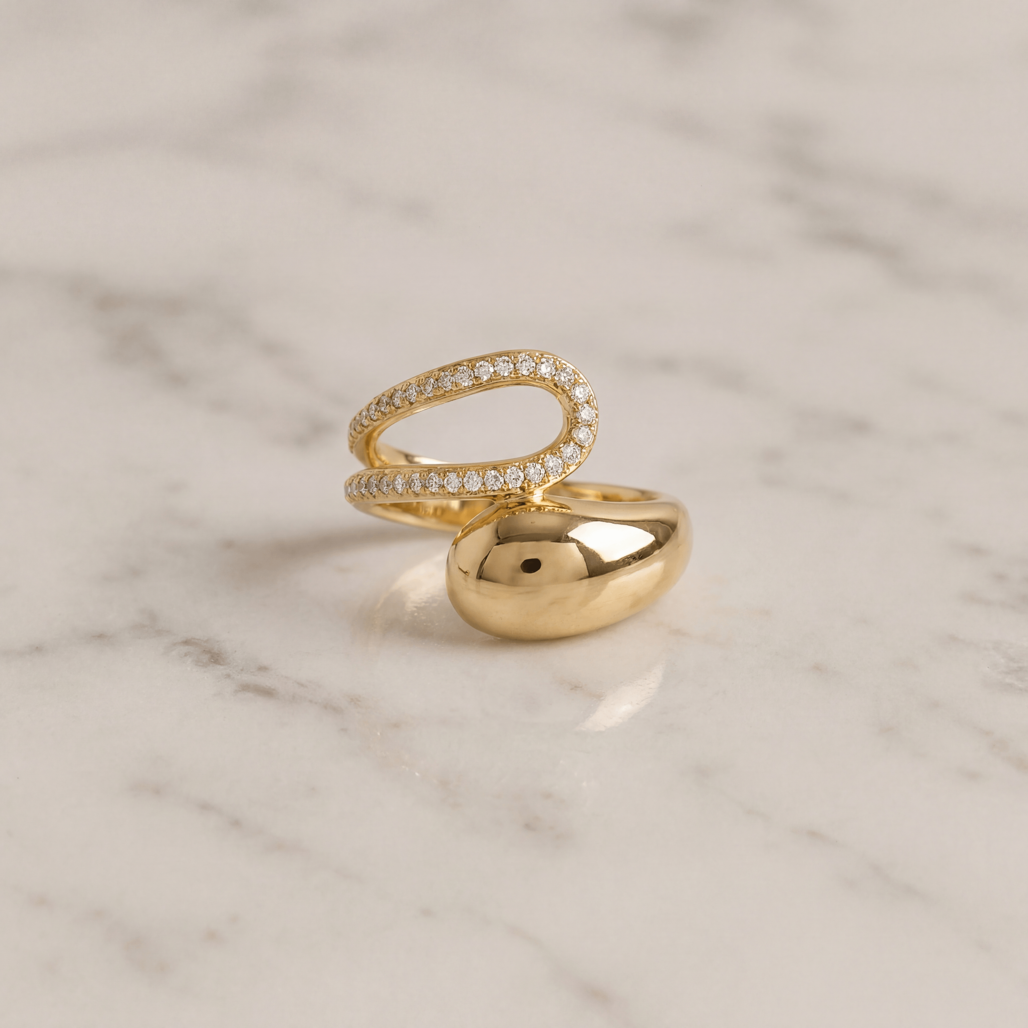 Bague bold zirconium posée sur du marbre blanc