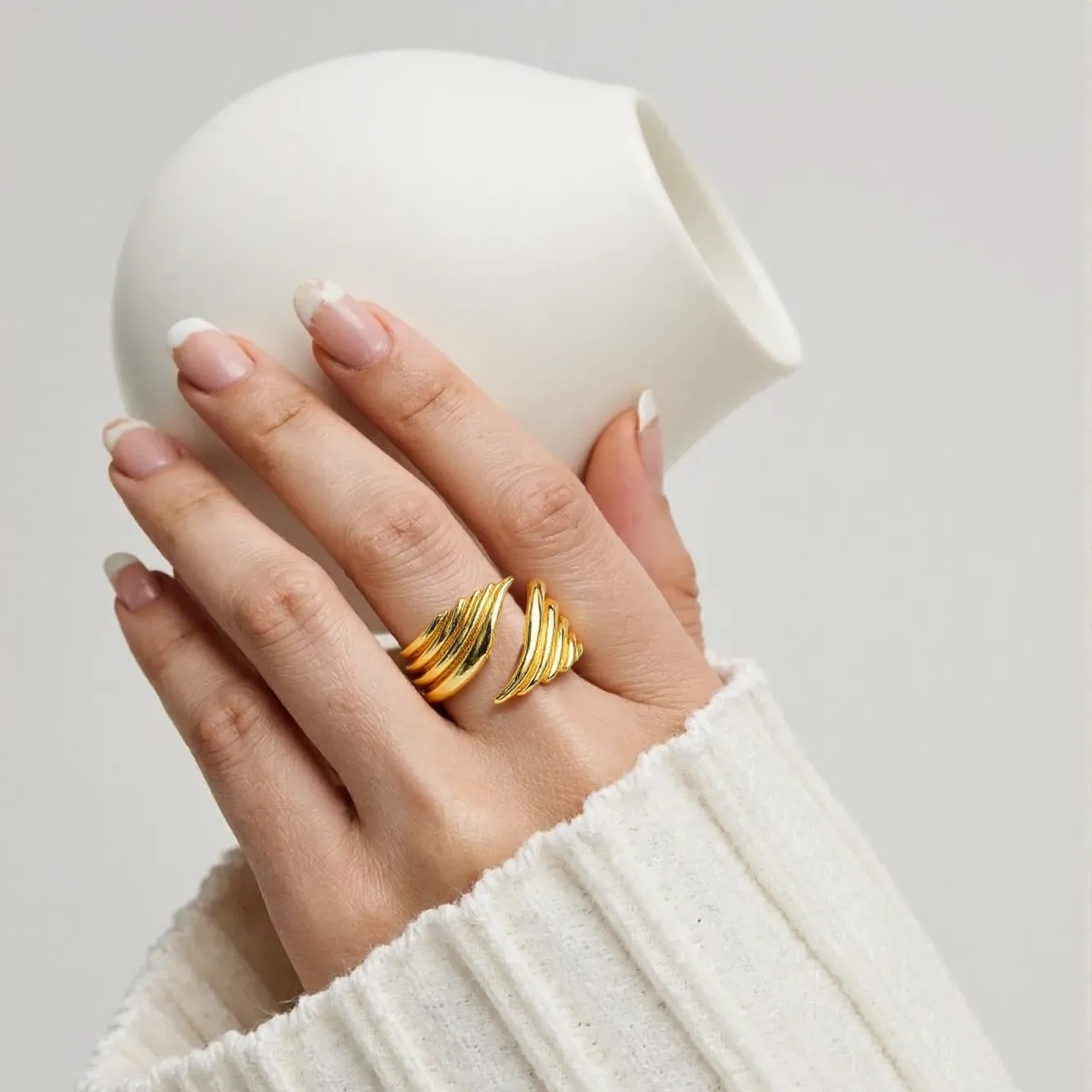 Femme porte une bague aile d'ange couleur or jaune