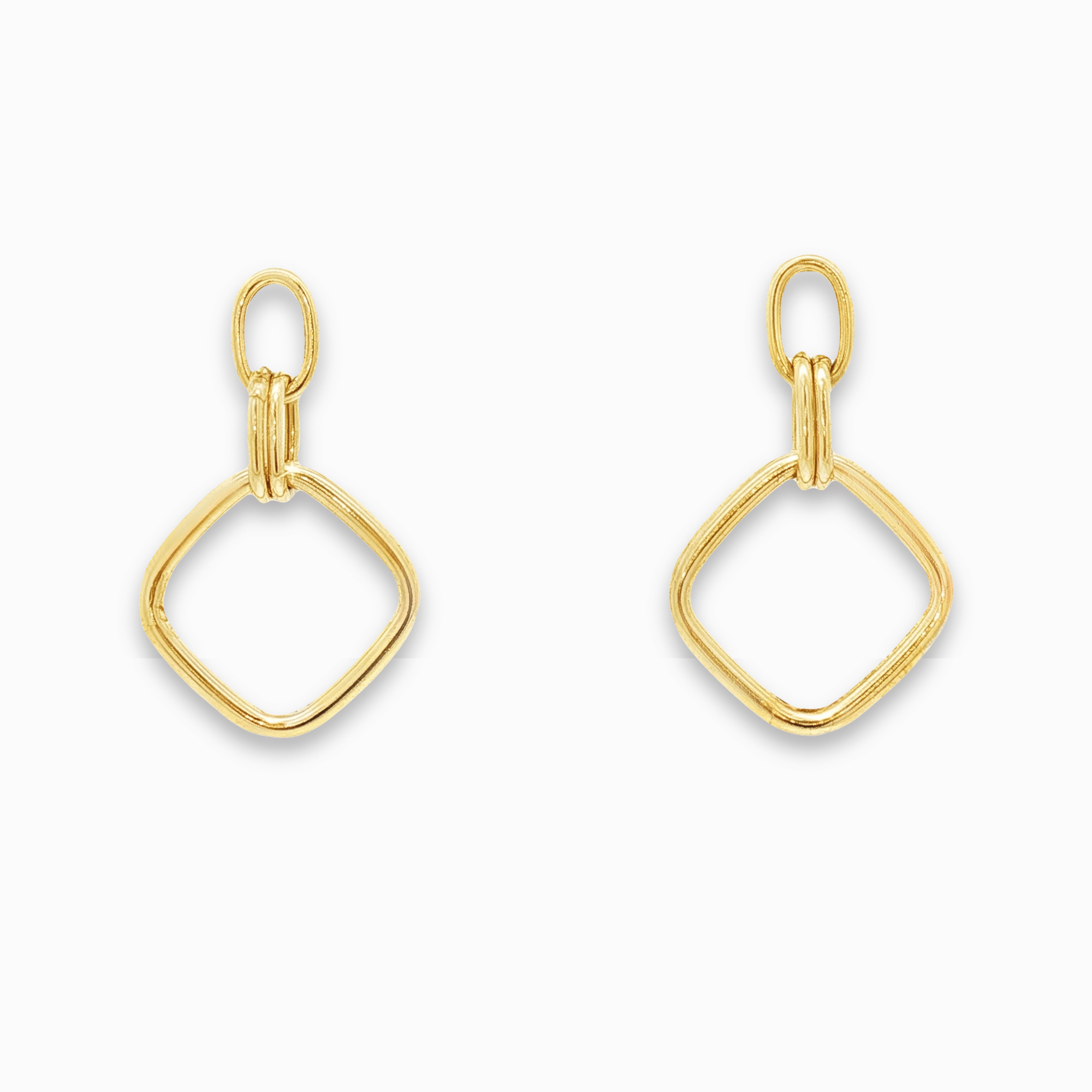 Boucles d'oreilles pendantes or de forme losange sur un fond blanc