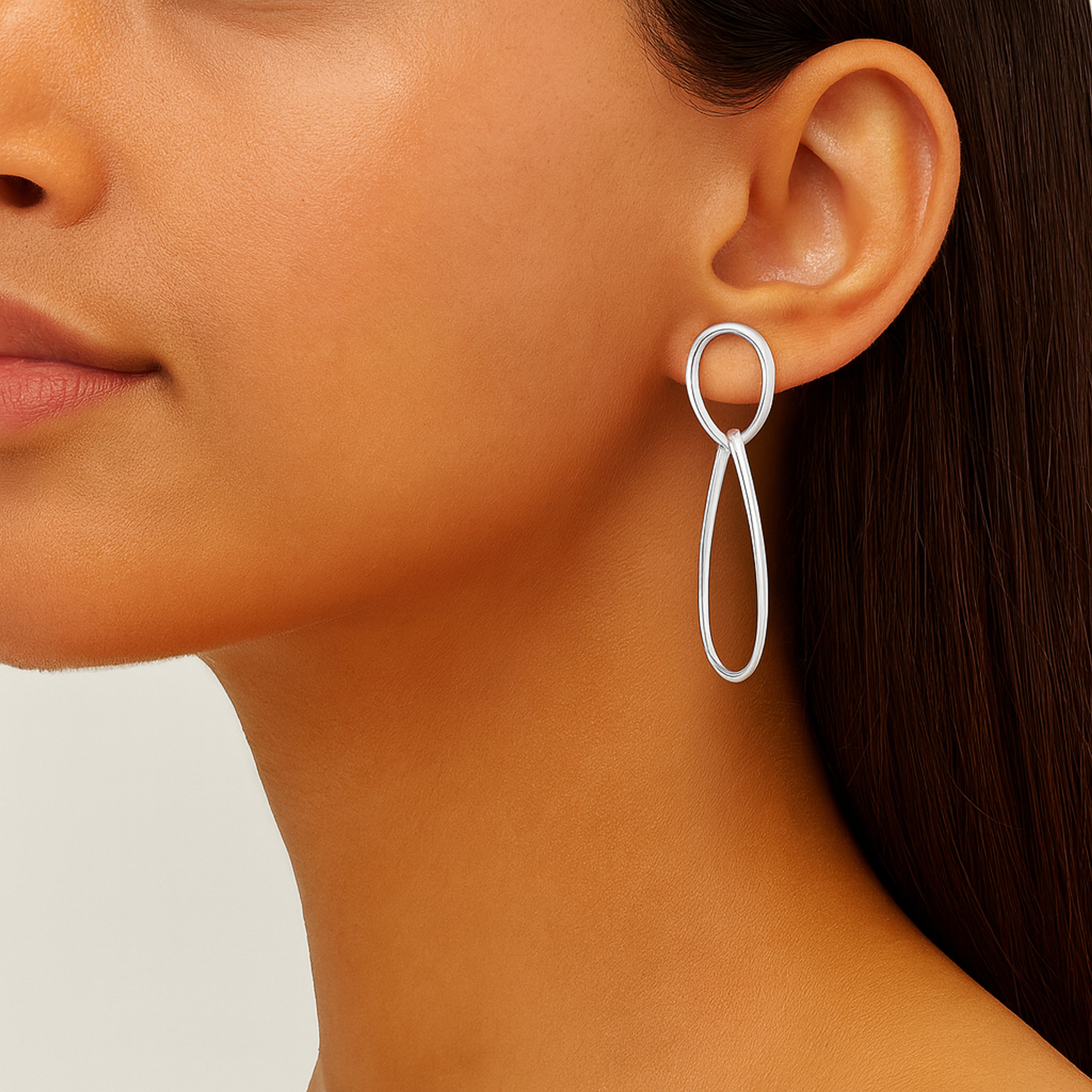 Boucles d'oreilles pendantes en argent portées par une femme
