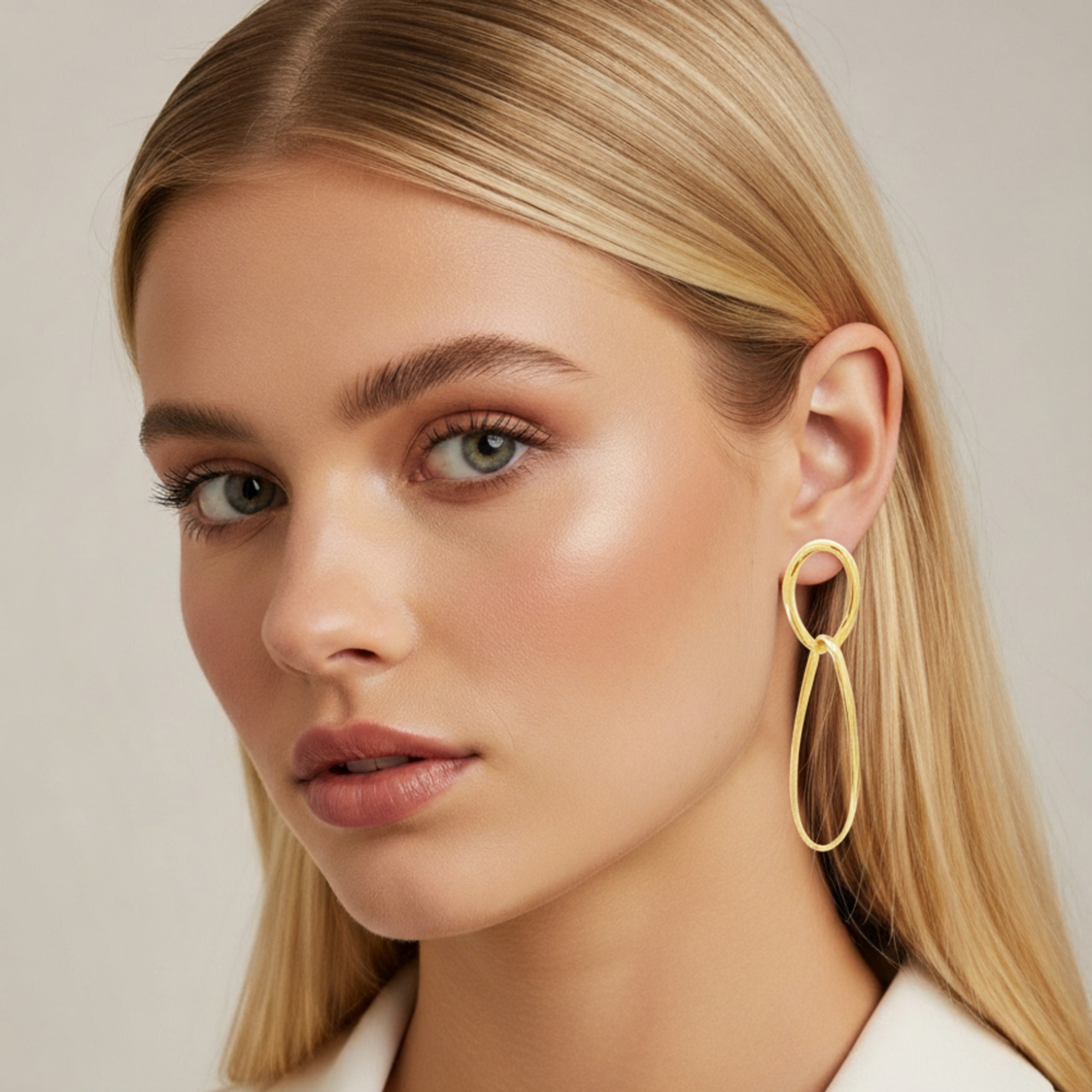 Boucles d'oreilles pendantes ovales portées par une femme blonde
