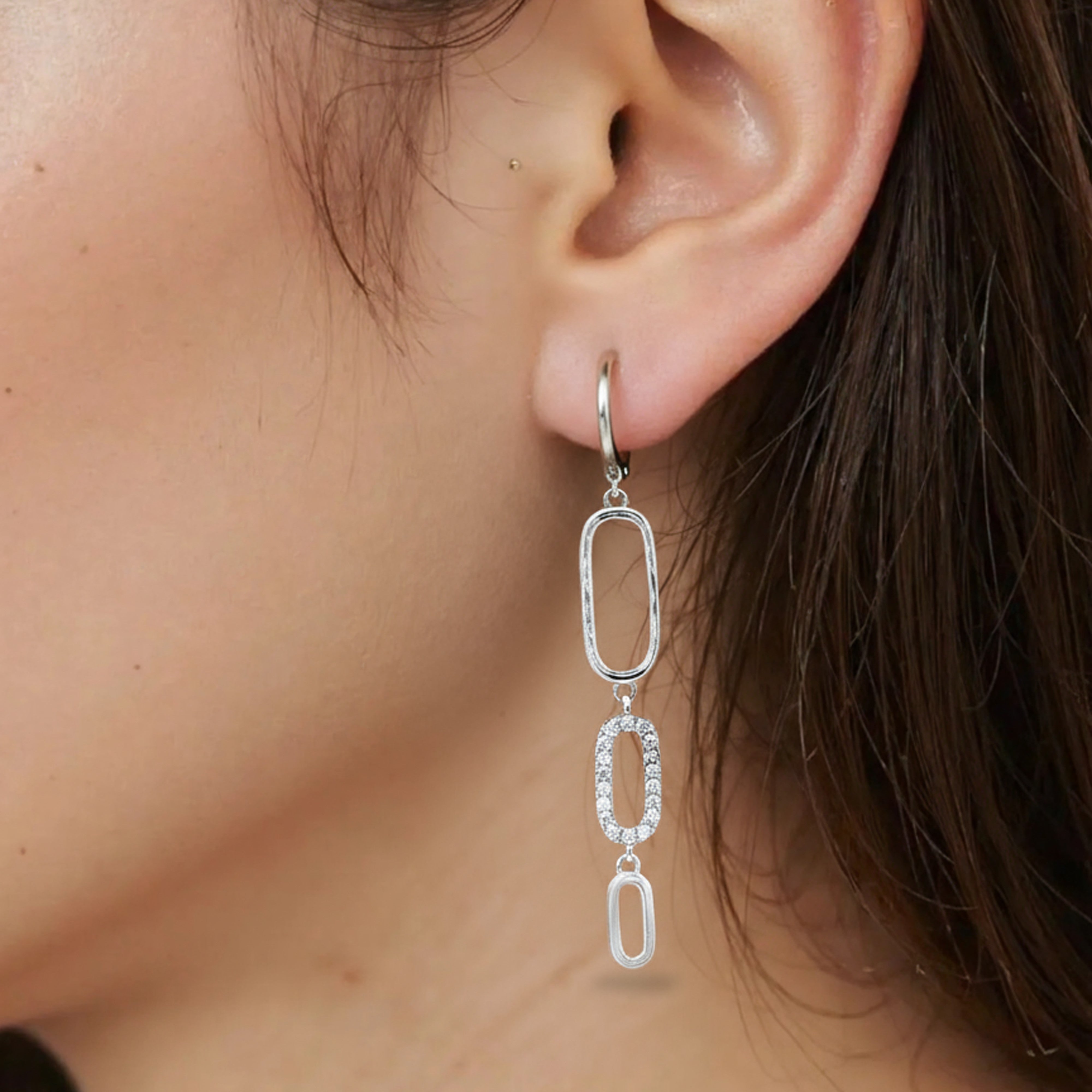 Boucles d'oreilles pendantes zircons portées par une femme