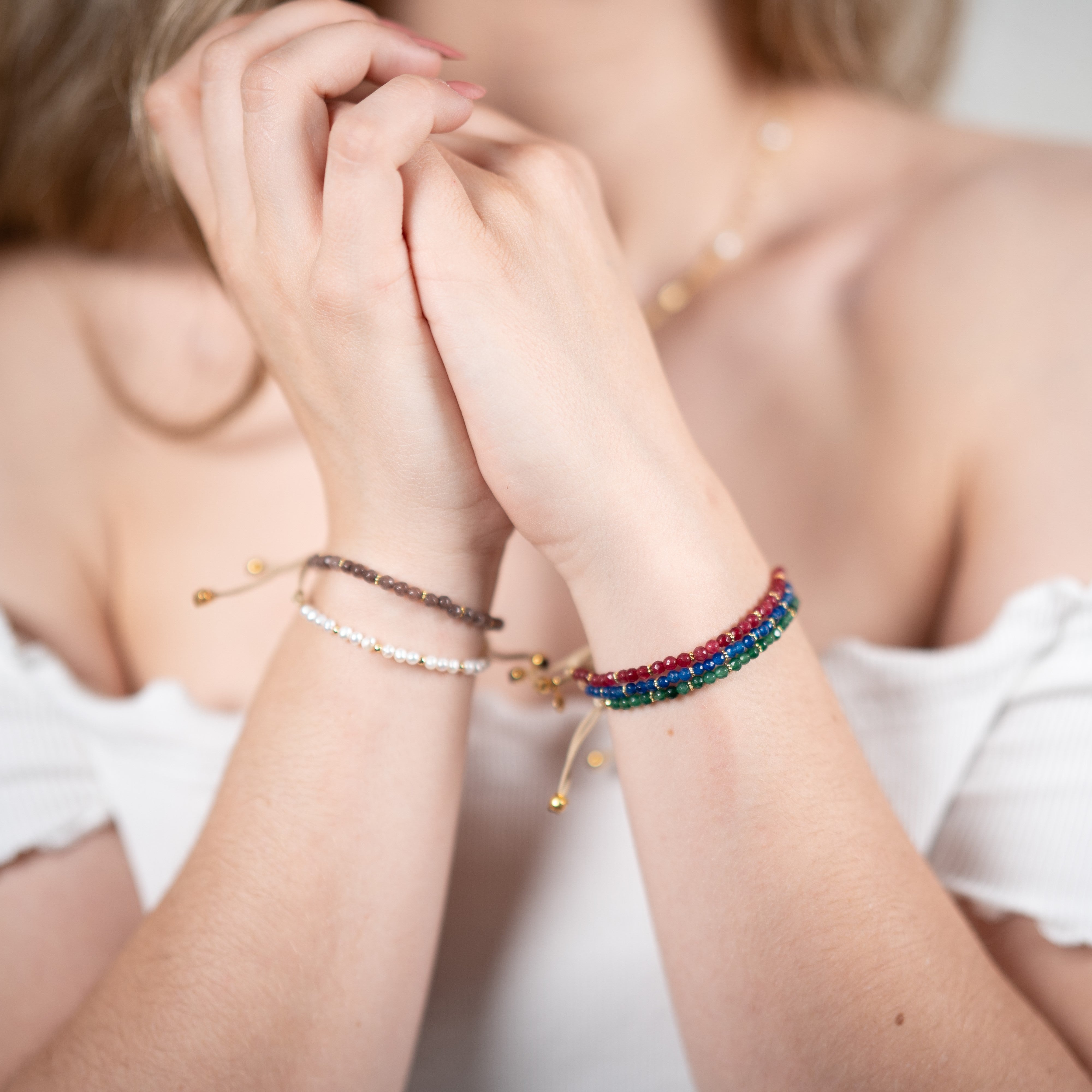 Quatre bracelets dont un bracelet quartz vert, un bracelet quartz rouge, un bracelet quartz fumé, un bracelet quartz bleu et un bracelet perles naturelles