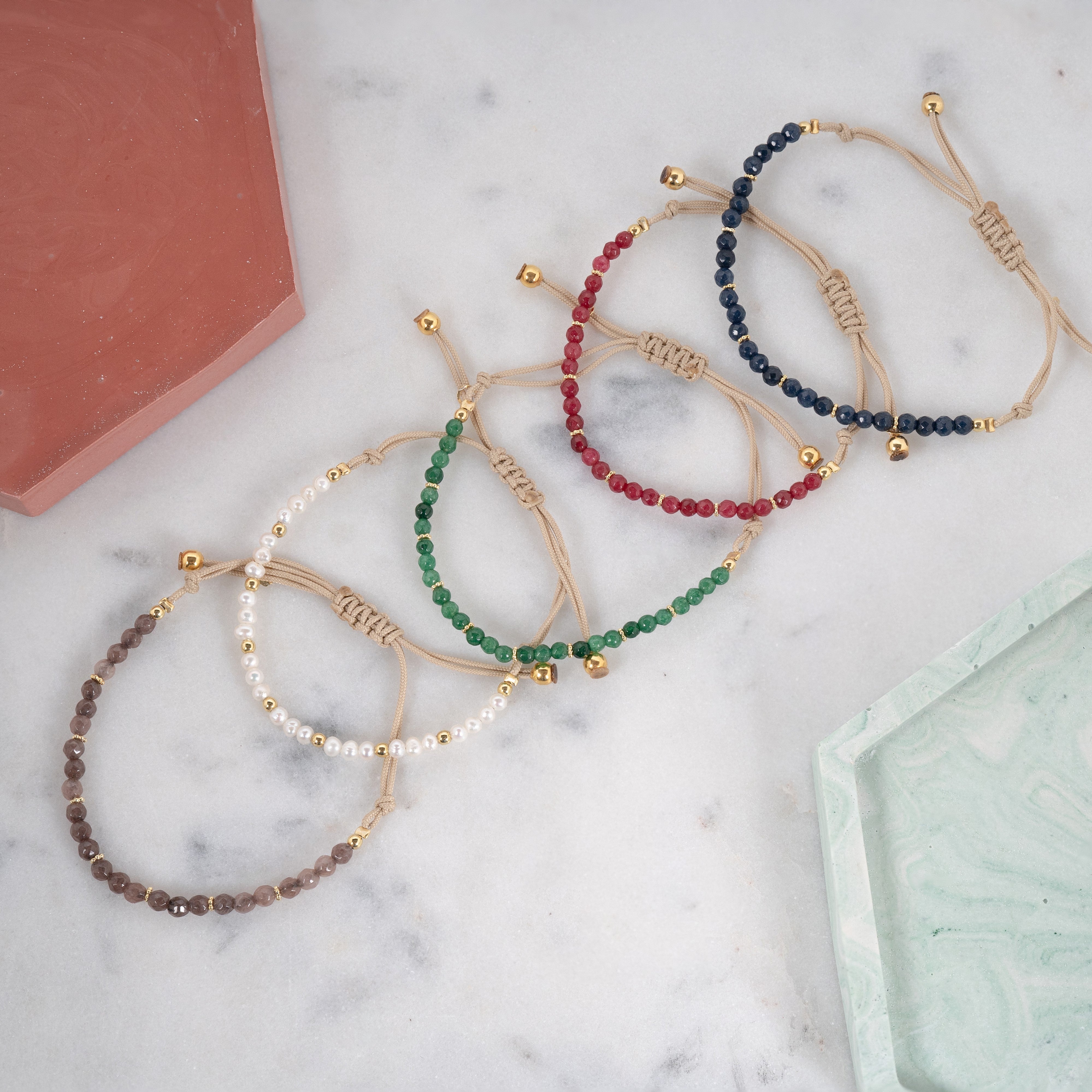 Cinq bracelets en coton avec des pierres de couleur