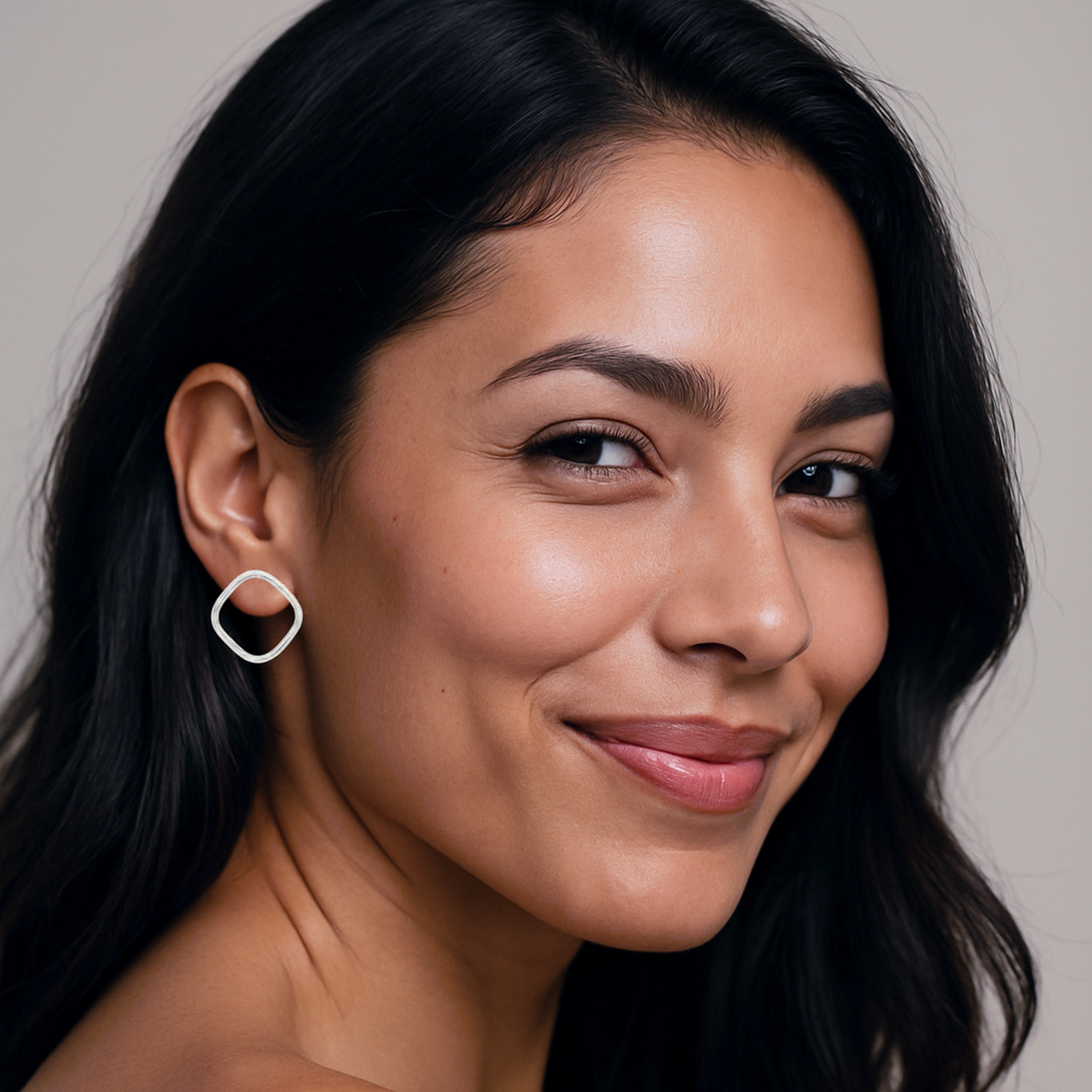 Boucles d'oreilles carrées en argent massif portées par une femme