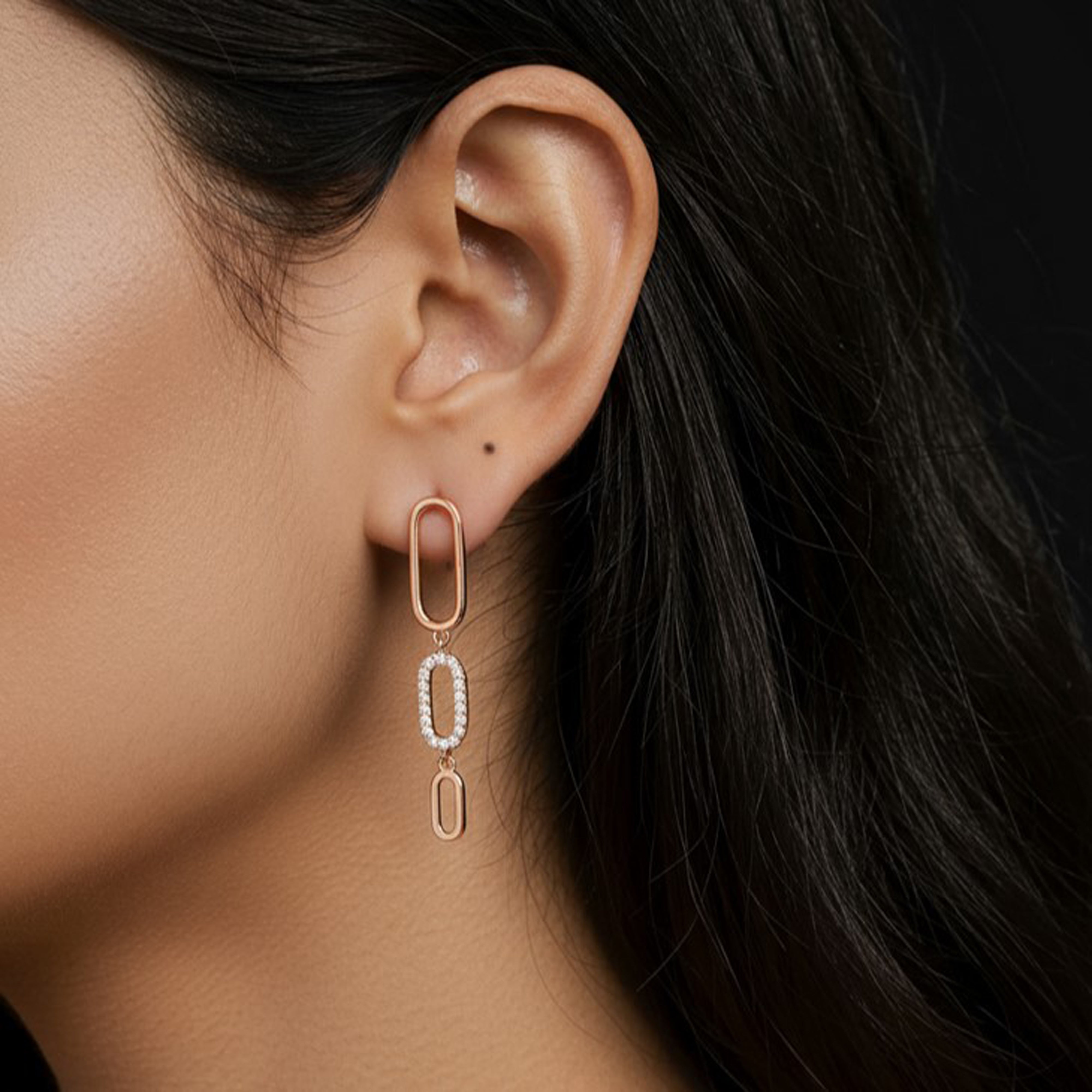 Boucles d'oreilles pendantes avec des zircons portées par une femme