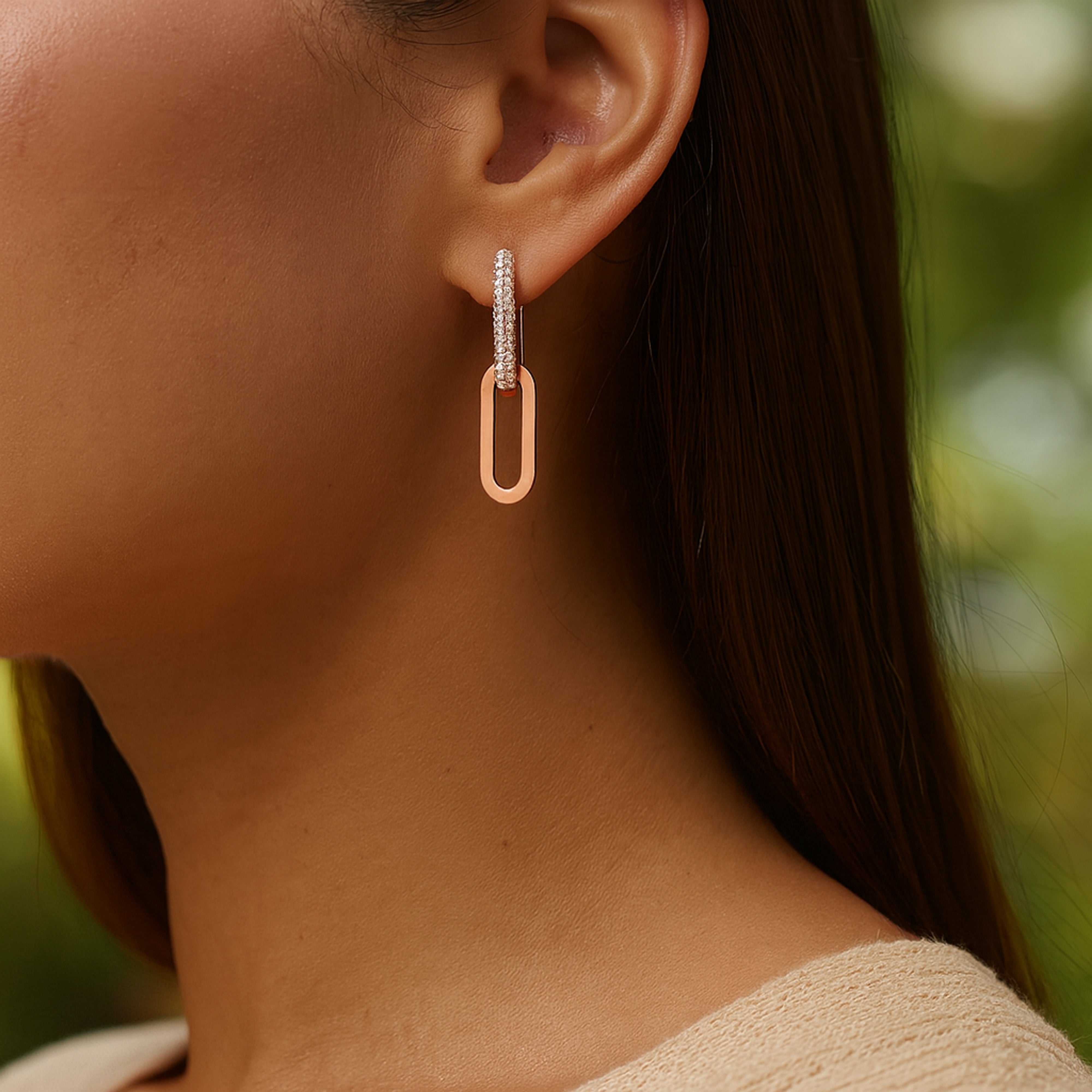 Une femme porte une boucle d'oreille zirconium avec son pendant en or rose
