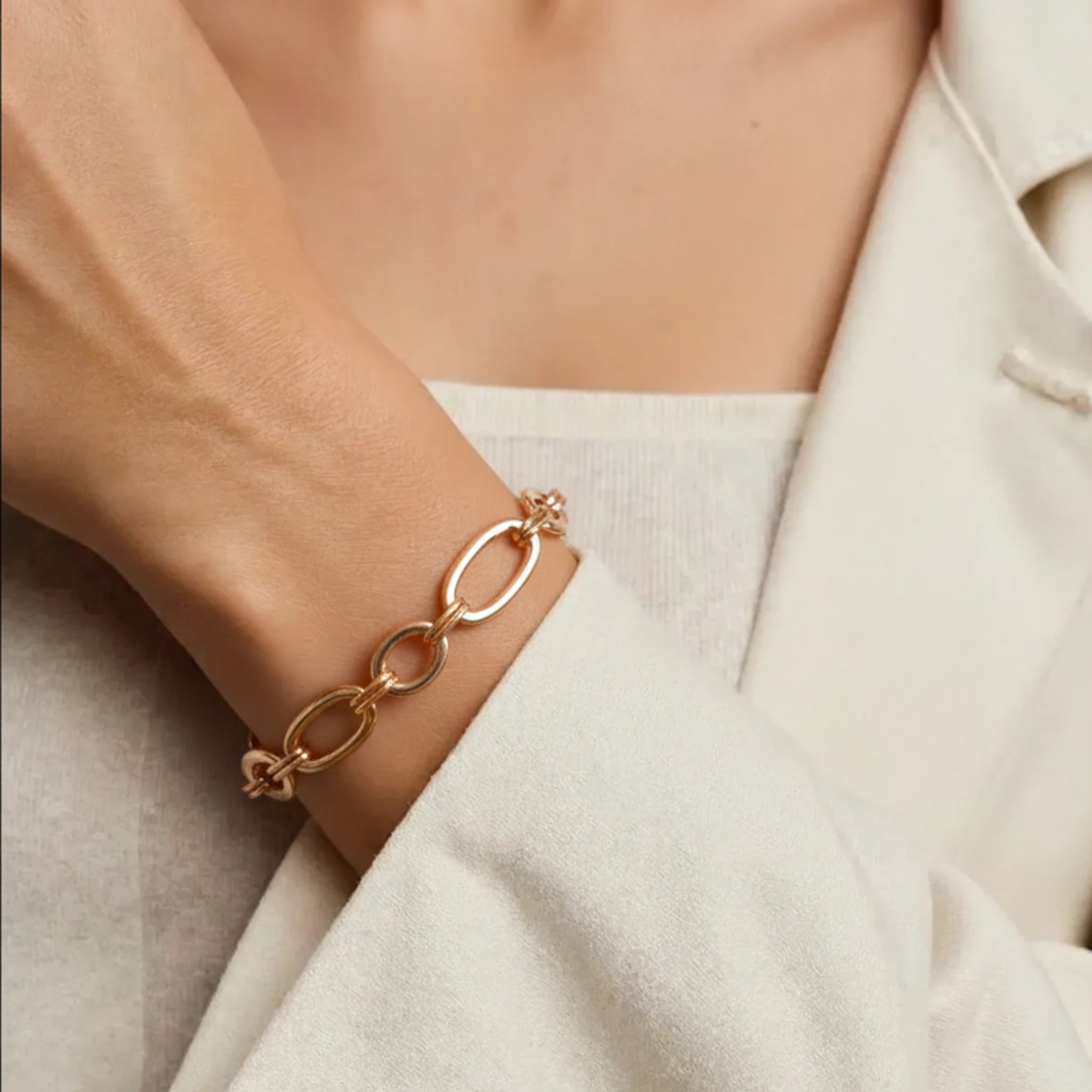 Femme portant au poignet un bracelet gros maillon or rose