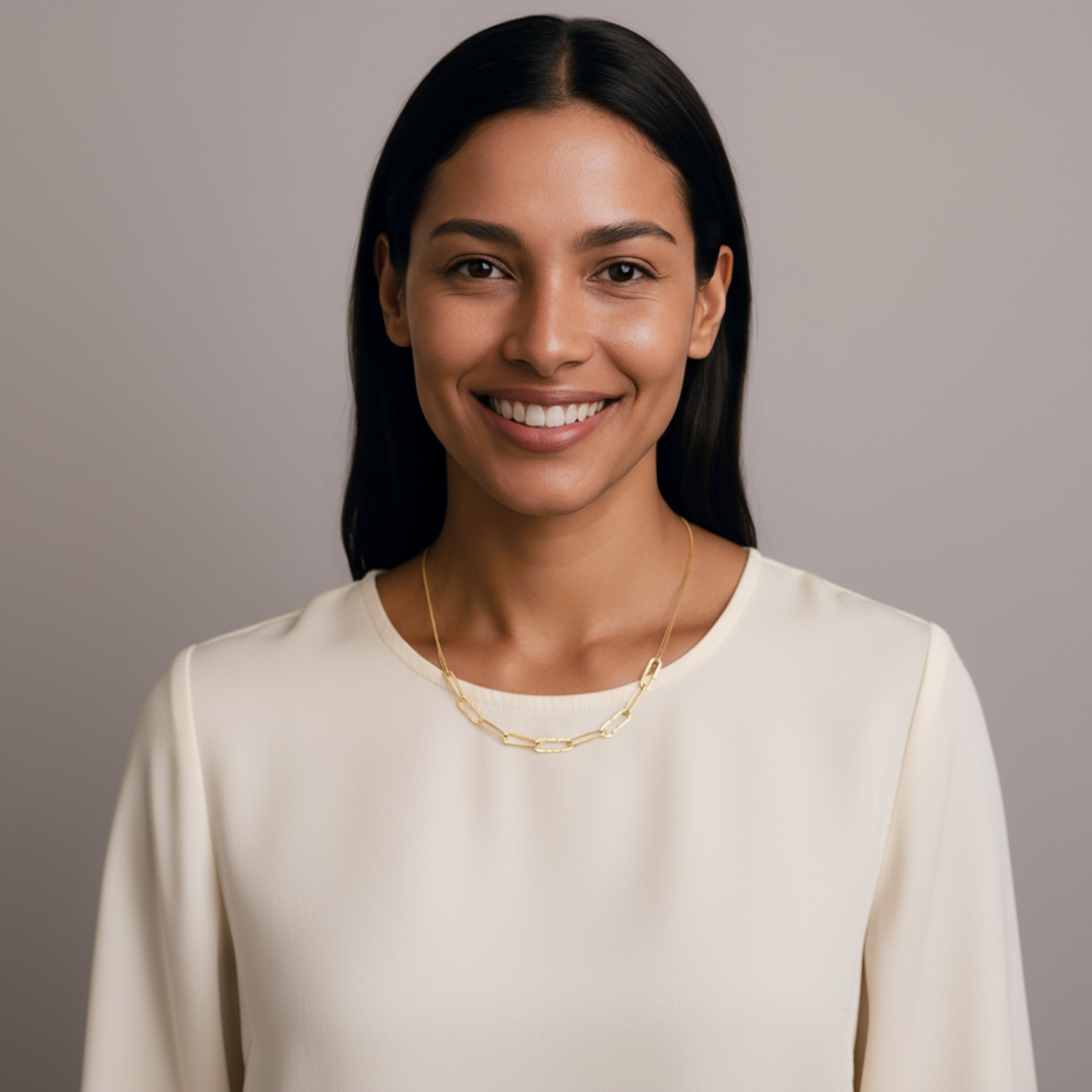 Femme portant un pull blanc avec un collier maillon frappé couleur or