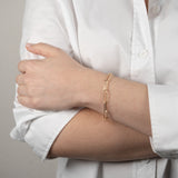 Bracelet aux longs maillons en argent couleur or jaune porté au poignet
