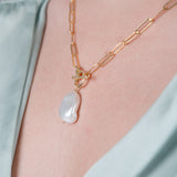 Collier couleur or jaune avec une perle naturelle et une chemise vert d'eau